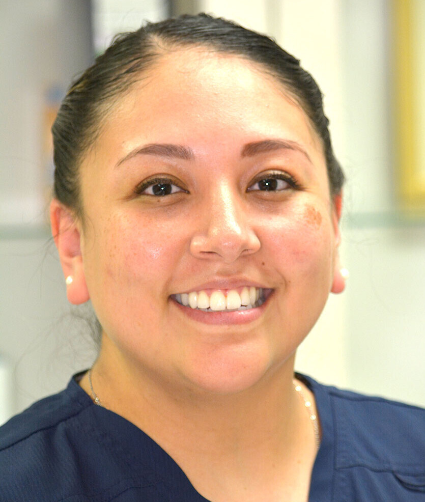 CLOSE UP PHOTO OF SMILING CLINICAL STAFF WOMAN